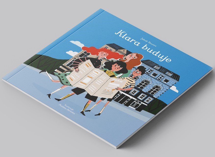 Okładka książki Klara buduje. Grupa dziewczynek czyta na ulicy rozkładany plan. W tle widać domy, a za nimi las i niebo.