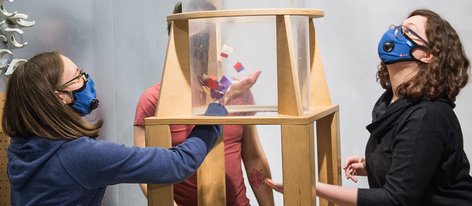 Trzy osoby przy zestawie Dmuchawa puszczają w dużej tubie zabawki