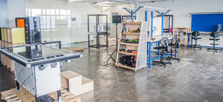 Na zdjęciu widać dużą salę wyposażoną w meble oraz sprzęt i narzędzia do prototypowania rozwiązań edukacyjnych.