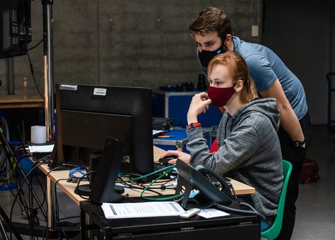 Dwoje ludzi wpatrzonych w monitor