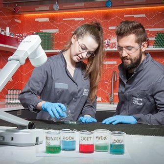 Laboranci przeprowadzają doświadczenie z użyciem kolorowych płynów