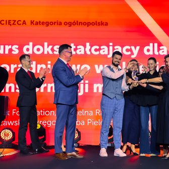 Grupa osób odbiera nagrodę za Kurs dla położnych „Poradnictwo w okresie transformacji menopauzalnej”.