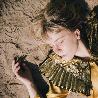 zdjęcie artystki leżącej na piasku