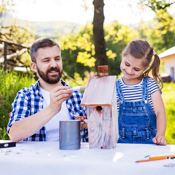 Zdjęcie ojca z córką przy domu dla ptaków.