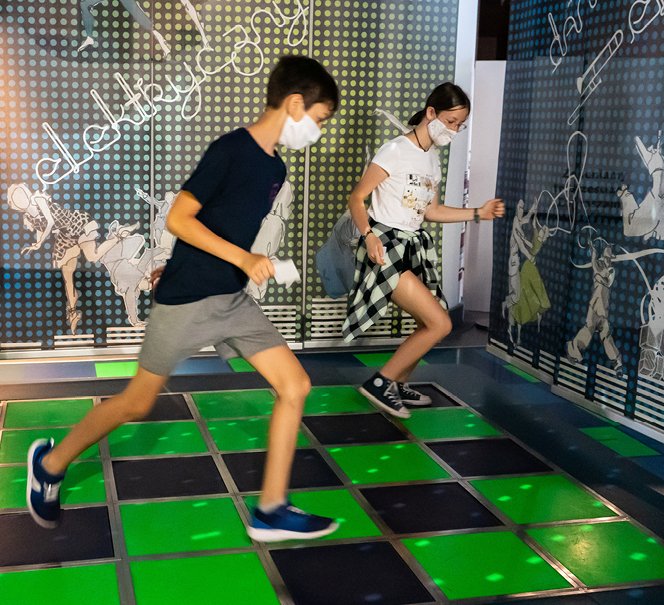 Młodzi ludzie skaczą po podłodze w eksponacie Tańcz 