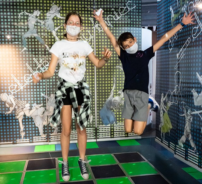 Młodzi ludzie skaczą po podłodze w eksponacie Tańcz 