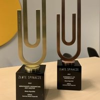 Zdjęcie dwóch statuetek w kształcie ogromnych spinaczy do papieru.