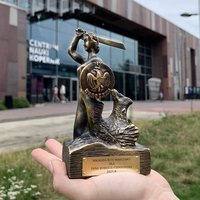 Nagroda - figurka syreny warszawskiej - na tle budynku Kopernika